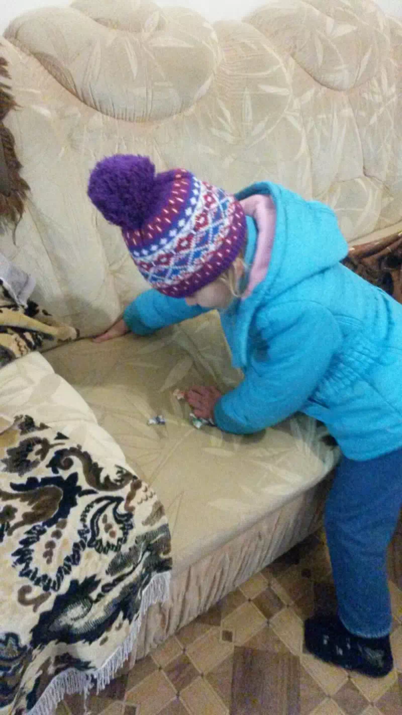 Девочка выполняя задание кеста ищет буковки спрятанные в внутри дивана