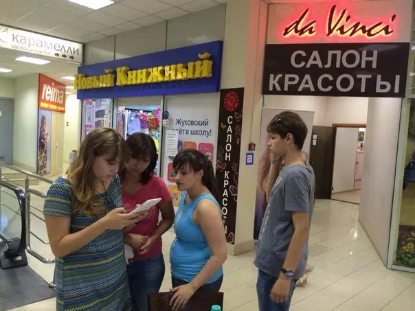 Девочки в торговом зале читают с планшета задания квеста