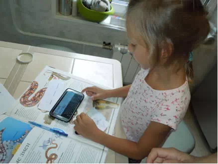 Девочка Маша держит телефон с заданием квеста
