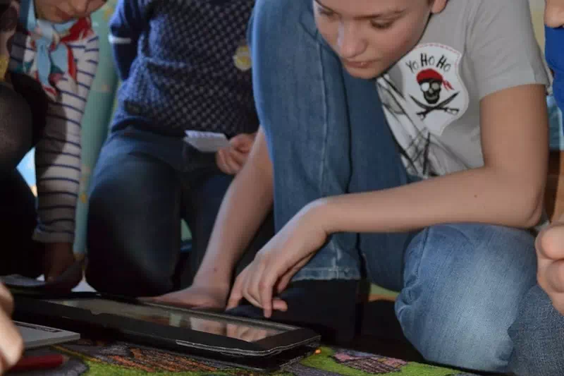 Дети играют в пиратский квест на планшете