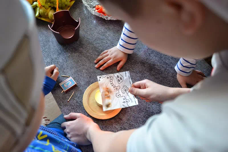 Дети получают секретное слово из пиратской карты держа ее над огнем
