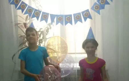 Дети позируют в шапочках для вечеринки в стиле Бравл Старс с шариками и флажками